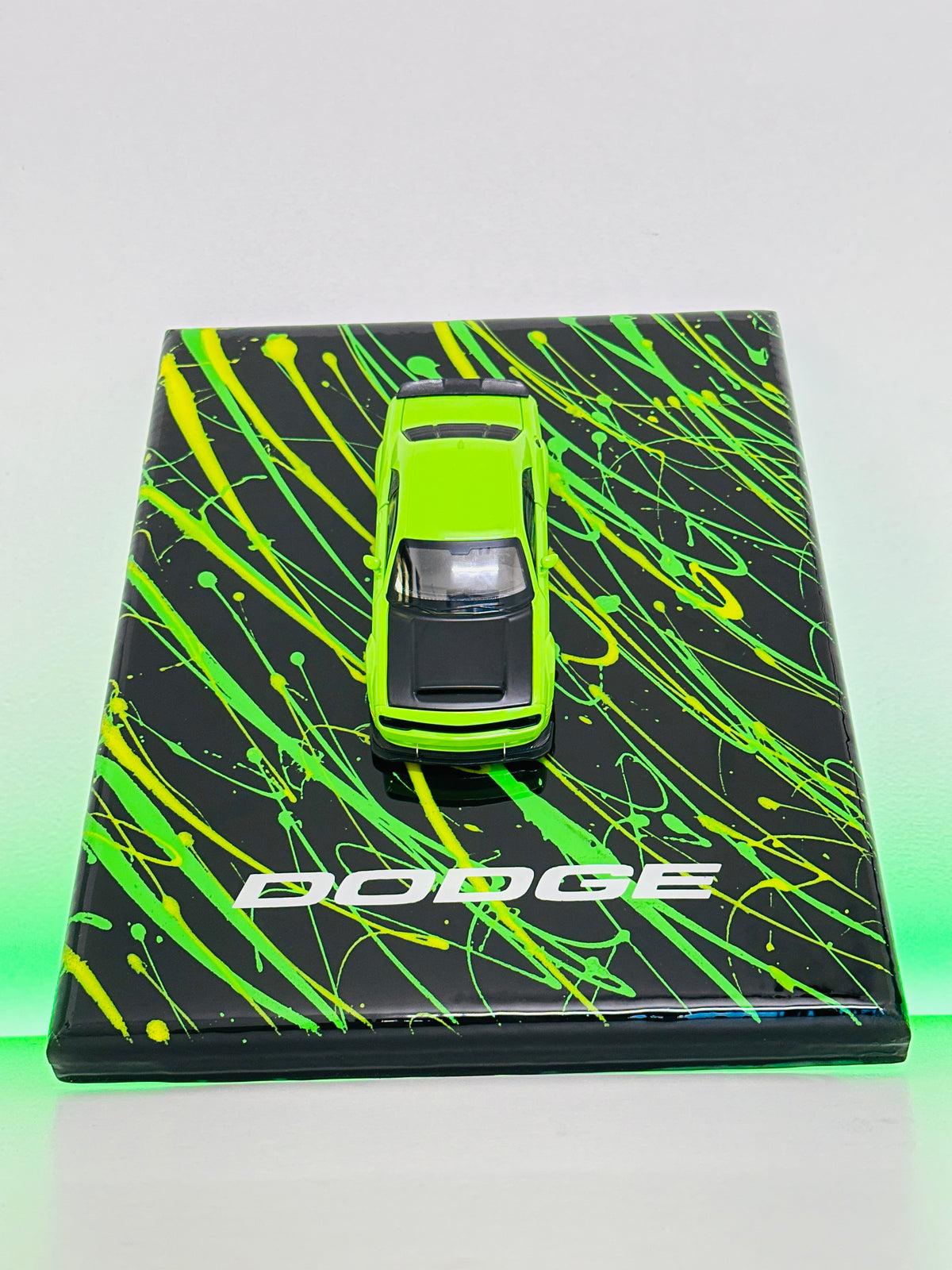 Dodge sports car miniature mounted on black and green display frame