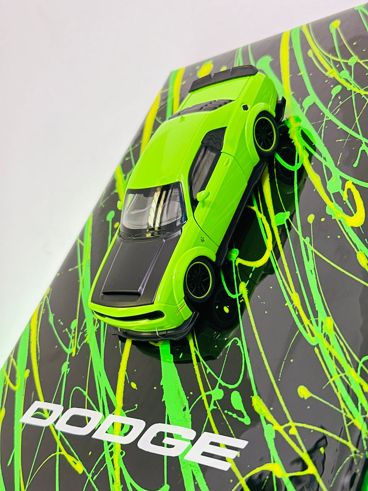 Dodge miniature car collector display with neon green splatter design