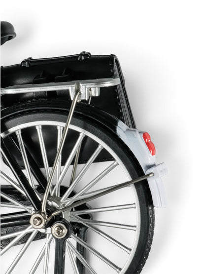 Focused on details: A small replica of a retro black bicycle resting on a kickstand, showcasing intricate chrome handlebars, pedals, and spoke wheels.