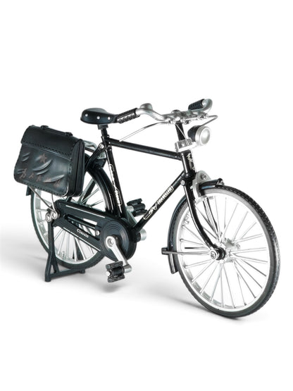  Short & direct: Miniature black vintage bicycle with silver wheels against a plain grey background.