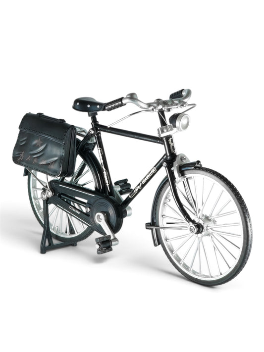  Short & direct: Miniature black vintage bicycle with silver wheels against a plain grey background.